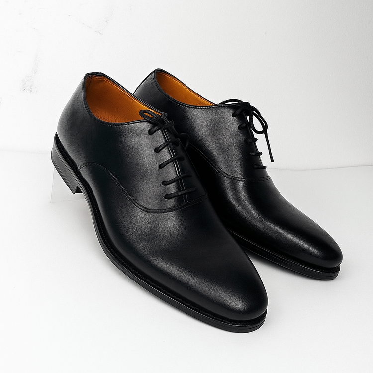 Pair of black leather dress shoes on a white background
