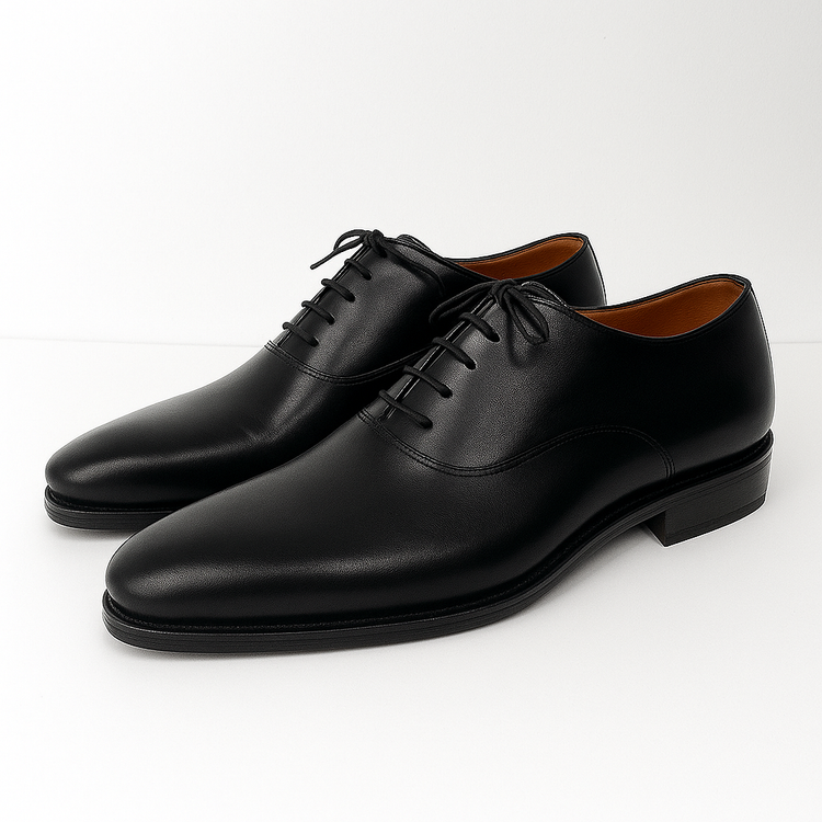 Pair of black leather dress shoes on a white background