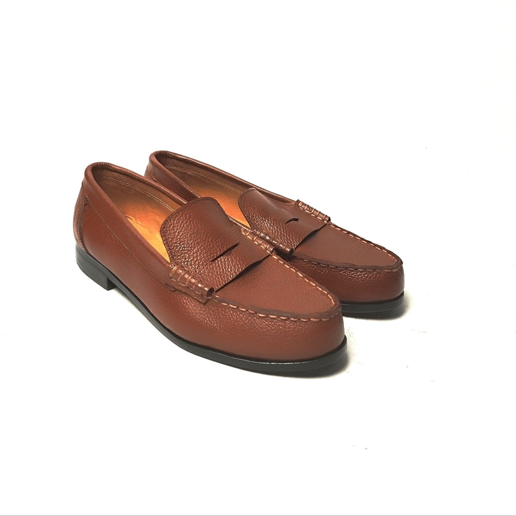 A pair of black leather penny loafers on a white background.