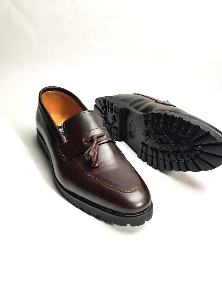 A pair of brown tassel gum loafers with a high sole, displayed against a white background.