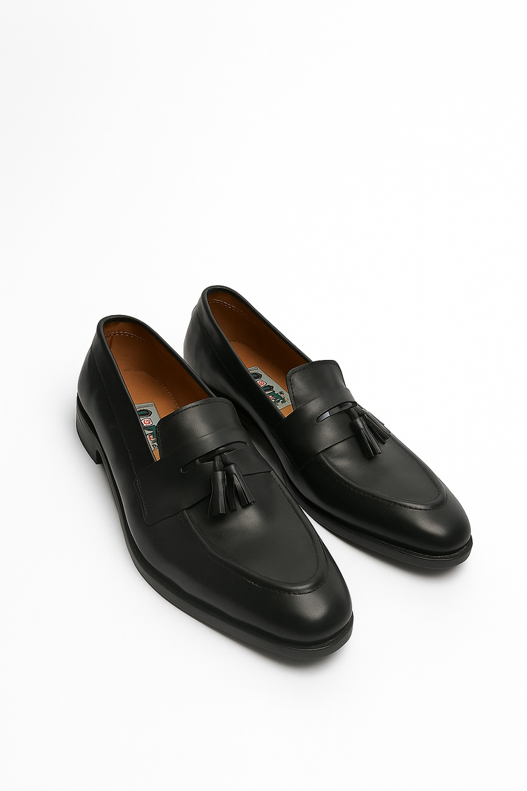 Black loafers with tassels on a white background
