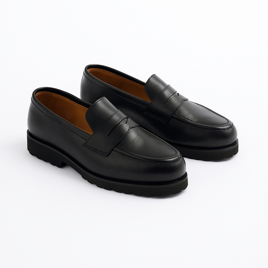 Pair of black loafers on a white background