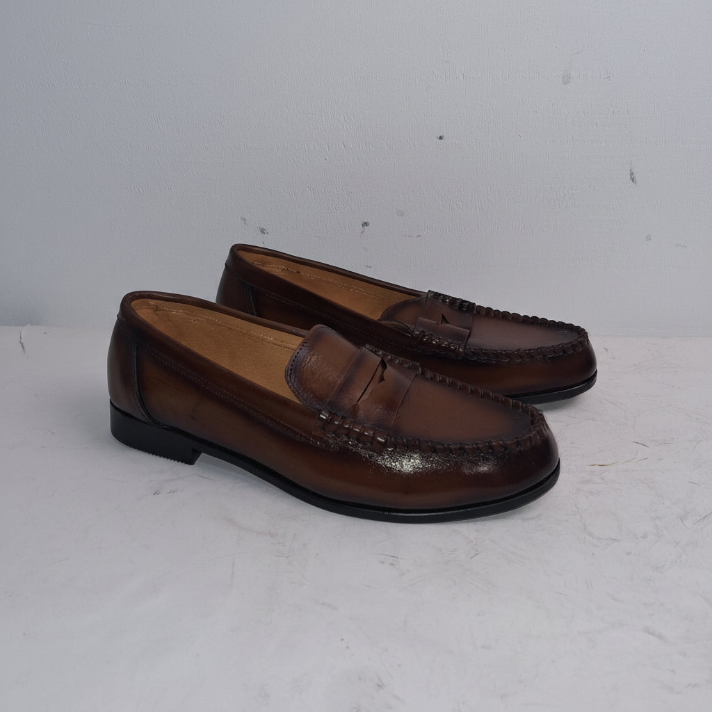 Pair of brown loafers on a white surface