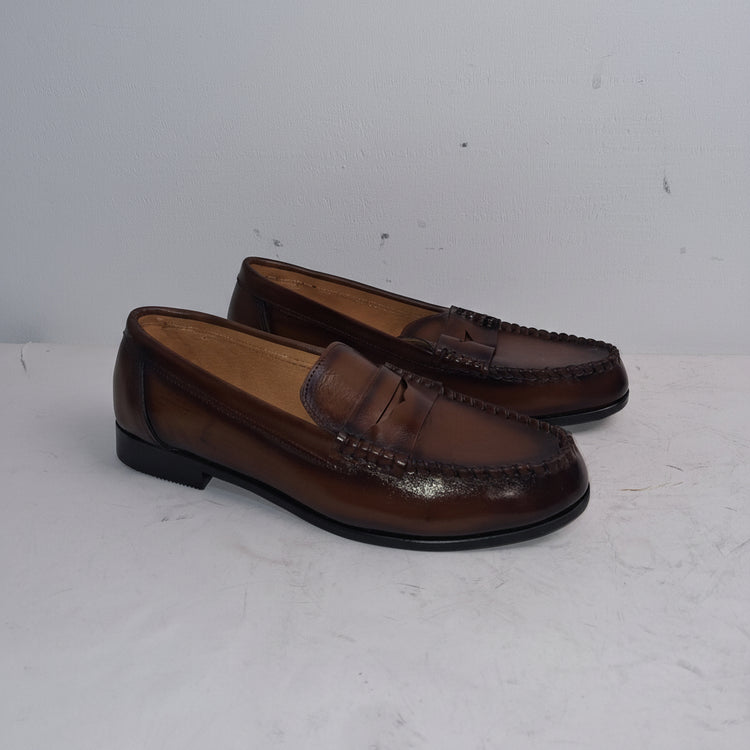 Pair of brown loafers on a white surface