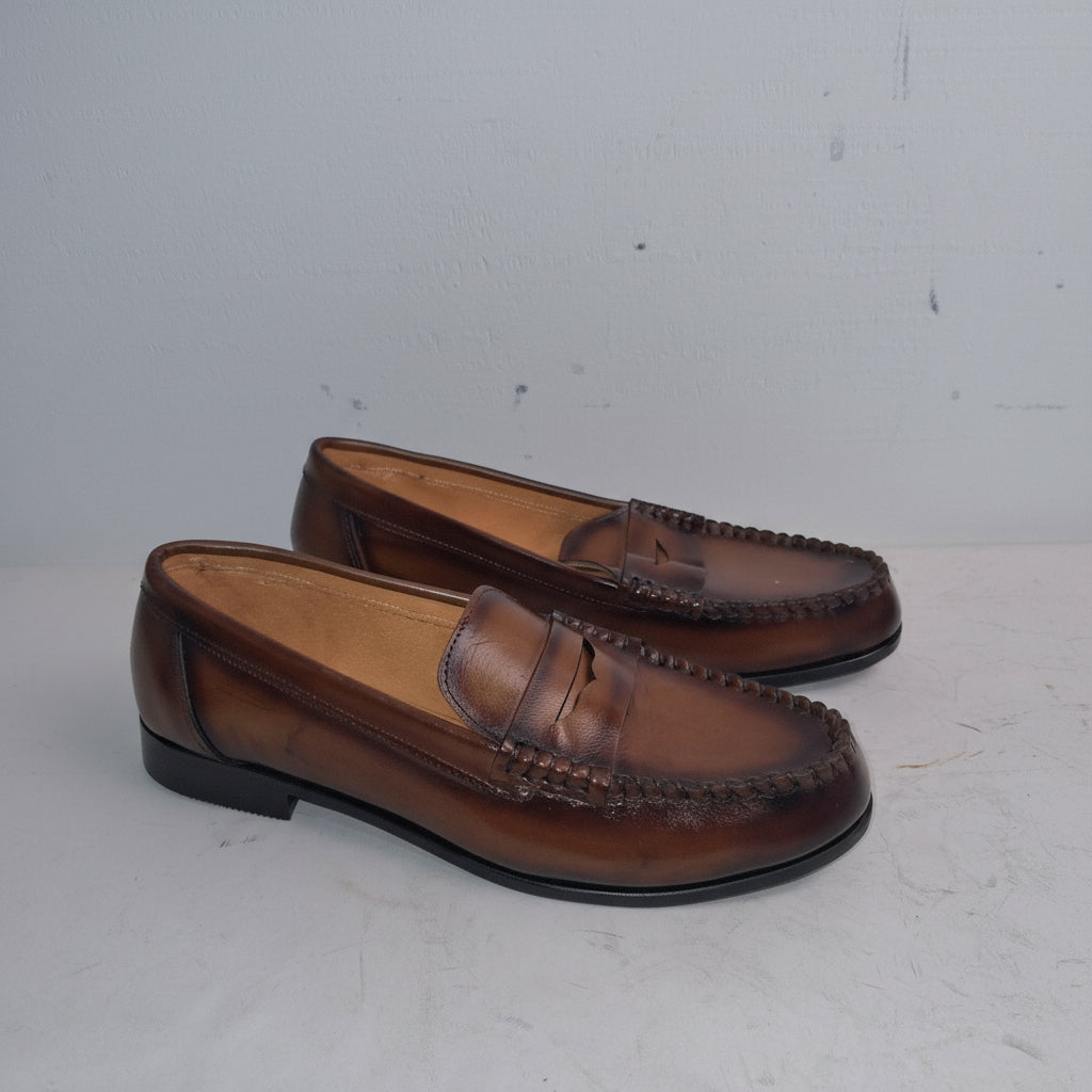 Pair of brown loafers on a light gray background