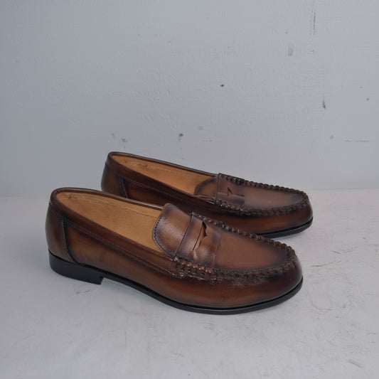 Pair of brown loafers on a light gray background