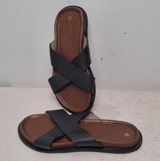 Pair of black sandals with brown soles on a light gray background