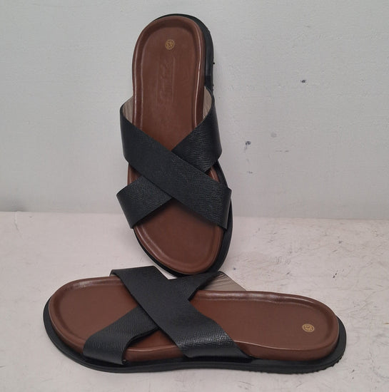 Pair of black sandals with brown soles on a light gray background